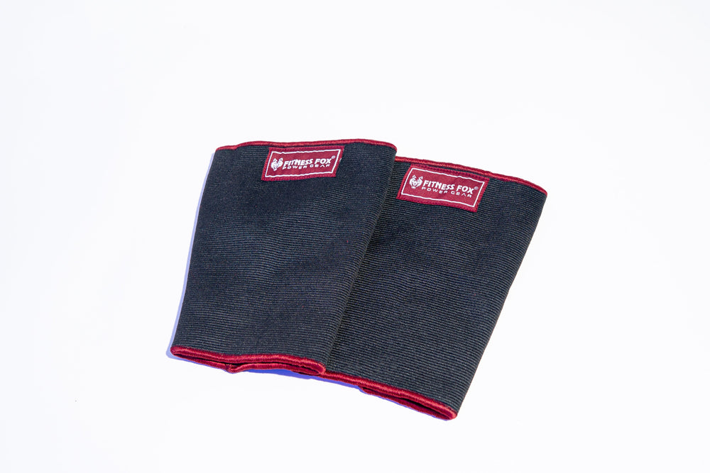 “Angled side profile of burgundy double-ply knee sleeves highlighting supportive elastic wrap that helps maintain a steady knee path under volume.”