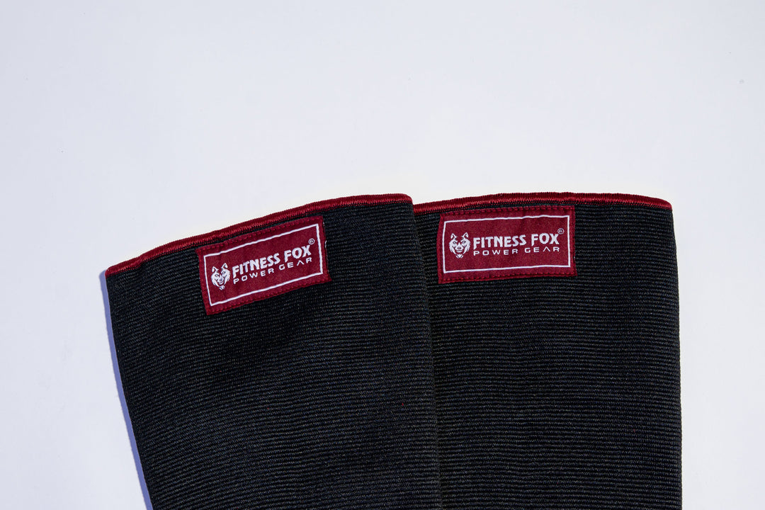 “Front view of Fitness Fox double-ply burgundy knee sleeves showing dense fabric and high-density stitching designed for durable compression during squat sessions.”