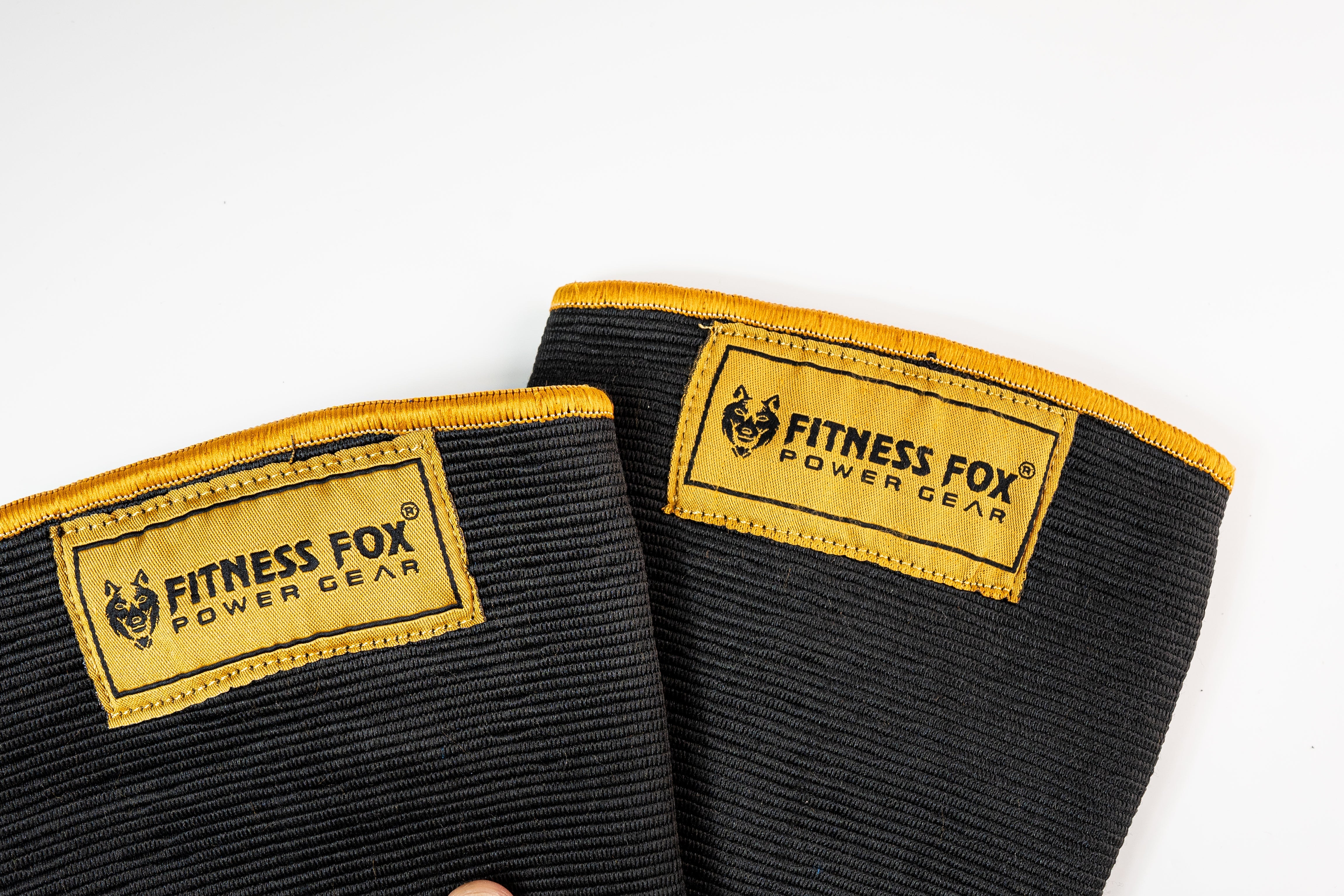 “Angled side profile of Black/Gold double-ply knee sleeves highlighting supportive elastic wrap that helps maintain a steady knee path under volume.”