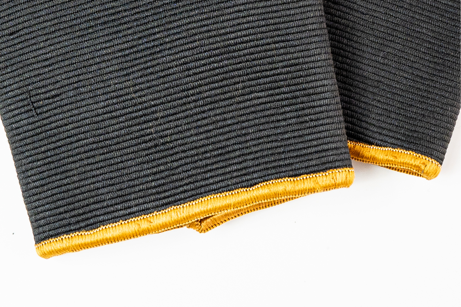 “Close-up detail of double-ply knit and high-density seams on Black/Gold knee sleeves designed for long-lasting support across heavy strength blocks.”