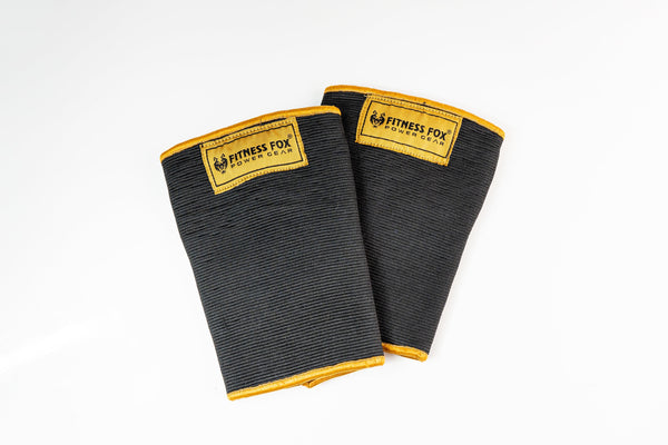 “Front view of Fitness Fox double-ply Black and Gold knee sleeves showing dense fabric and reinforced stitching for durable compression on squat days.”